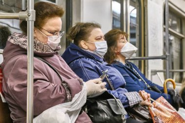 Rusya Haziran 2020. Moskova metrosu. Koruyucu maskeli insanlar metro vagonuna binerler. Rusya 'da koronavirüs salgını. Virüs bulaşma riski var. renk