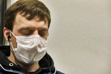 Rusya Haziran 2020. Moskova metrosu. Koruyucu maskeli bir adam metro vagonuna gözleri kapalı biniyor. Rusya 'da koronavirüs salgını. Virüs bulaşma riski var. renk