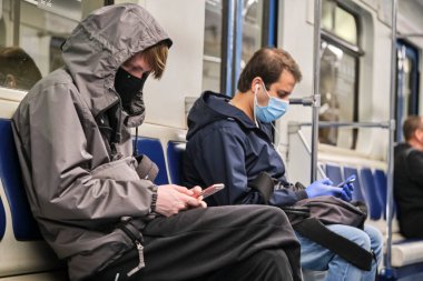 Rusya Haziran 2020. Moskova metrosu. Koruyucu maskeli insanlar metro vagonuna binerler. Rusya 'da koronavirüs salgını. Virüs bulaşma riski var. renk
