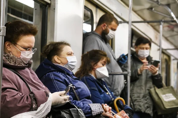 Rusya Haziran 2020. Moskova metrosu. Koruyucu maskeli insanlar metro vagonuna binerler. Rusya 'da koronavirüs salgını. Virüs bulaşma riski var. renk