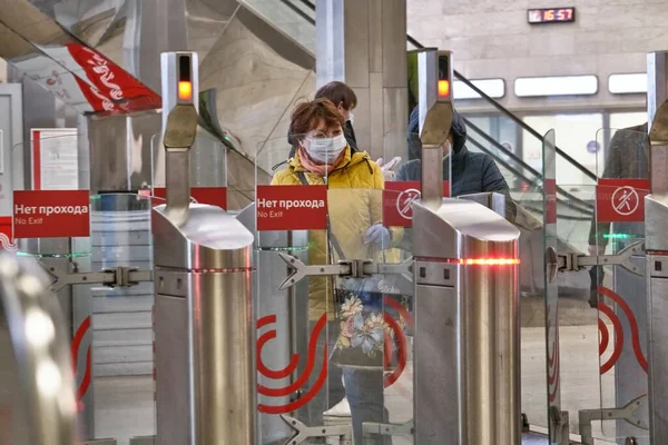 Rusya Haziran 2020. Moskova metrosu. Koruyucu maskeli bir kadın Moskova metrosunun girişindeki turnikelerden geçiyor. Rusya 'da koronavirüs salgını. Virüs bulaşma riski var. renk