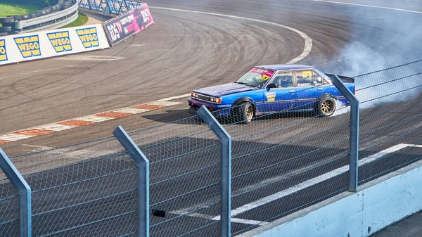 Rusya Ryazan Uluslararası Track Atron Eylül 2020. Pistte kontrollü patinaj yapan bir spor araba. Tekerleklerin altından duman yükseliyor