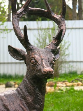 Yaz bahçesinde bronz bir geyik heykeli