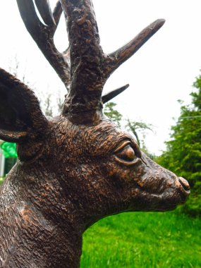 Yaz bahçesinde bronz bir geyik heykeli