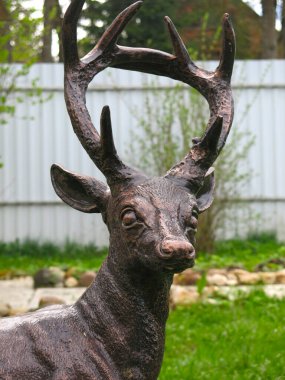 Yaz bahçesinde bronz bir geyik heykeli