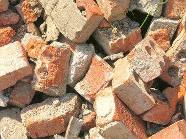 Kırık tuğlalar bir inşaat atığı yığınının içinde yatıyor.