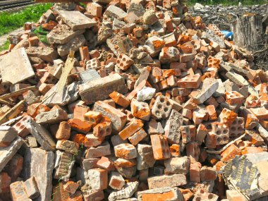 Kırık tuğlalar bir inşaat atığı yığınının içinde yatıyor.
