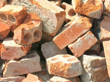 Kırık tuğlalar bir inşaat atığı yığınının içinde yatıyor.