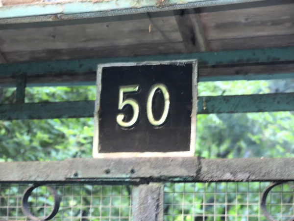 number 50 on a black background, house number plate