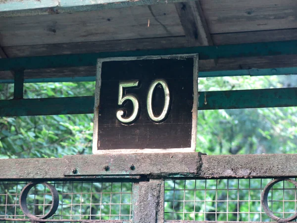 number 50 on a black background, house number plate