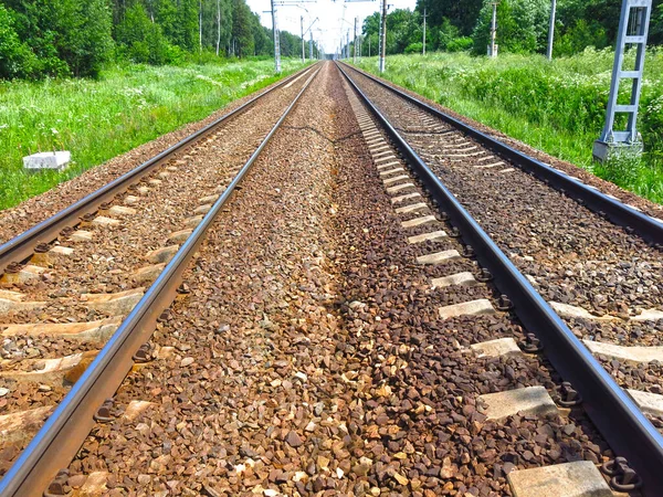 晴れた日の夏には線路が遠くに伸びています — ストック写真