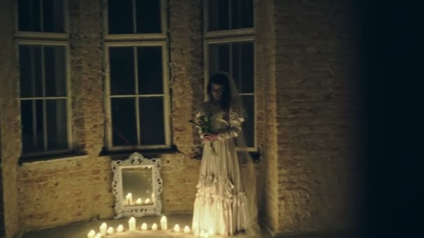 Nuit de peur, fantôme dans une maison hantée, femme mystérieuse en robe blanche et bougies en cercle . — Video