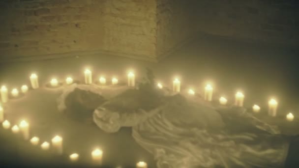 Scena dolorosa di una sposa cadavere sul pavimento come un rituale con candele — Video Stock