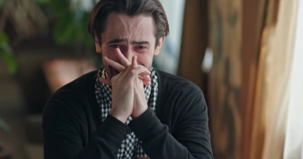 Een jonge, knappe man huilt zenuwachtig en op de rand van een zenuwinzinking terwijl hij zorgzaam zichzelf in de kamer. — Stockvideo