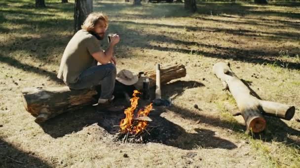 Mannen vid en eld i skogen - slowmotion — Stockvideo