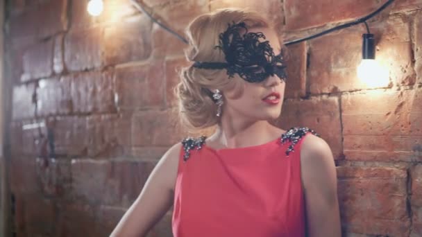 Mooie blonde meisje in prachtige rode jurk met een masker op haar gezicht in een vintage sfeer. Ruwe videoverslag. — Stockvideo