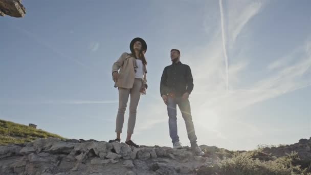 Pareja viajera en tierra rocosa a la luz del sol — Vídeos de Stock