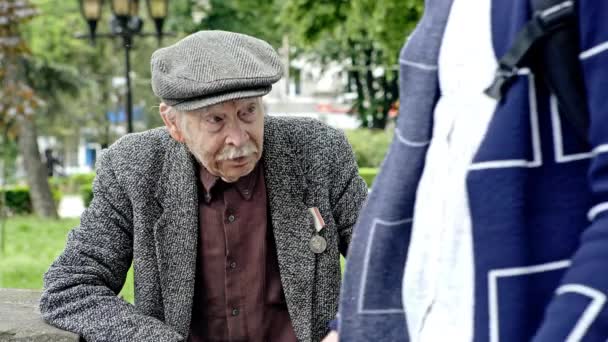 Старик с тростью отдыхает в парке — стоковое видео