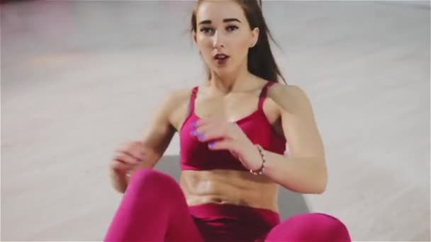 Όμορφη γυναίκα ασκεί κοιλιακούς στο γυμναστήριο — Αρχείο Βίντεο