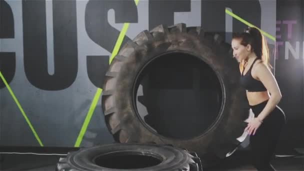Mulher ativa pulando no pneu de treinamento no ginásio — Vídeo de Stock