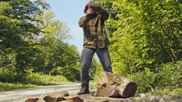 Güçlü kas adam ahşap bir baltayla yarma — Stok video