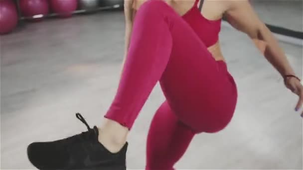 Подходит молодая женщина, прыгающая во время тренировки в спортзале — стоковое видео