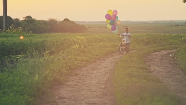 Kleiner Junge mit Fahrrad bei Sonnenuntergang. Rohe Videoaufzeichnung. — Stockvideo