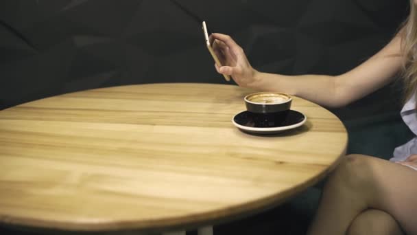 Side view of attractive young woman waiting something in coffee shop — Stock Video