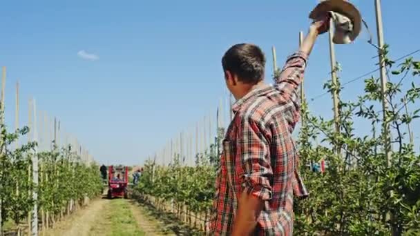 Campesino saludando a un peón conduciendo un tractor — Vídeo de stock