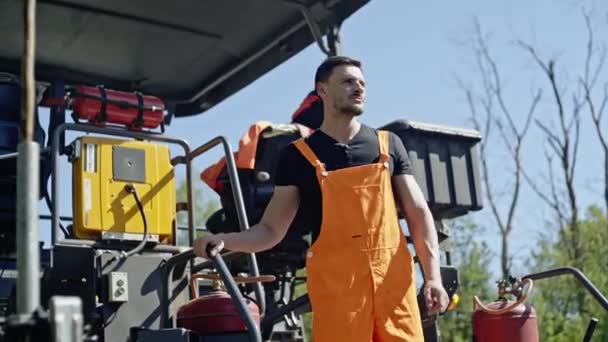 Lavoratore in piedi vicino a macchinari pesanti — Video Stock