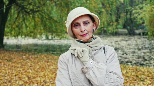 Eleganta äldre kvinna i höst park — Stockvideo