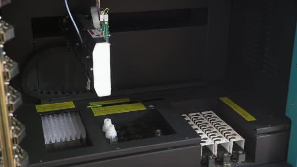 Mechanické kovové rameno přesunutí a rozšíření špičatý přívěsek zároveň uvnitř černé plastové experimentu box s bílým materiály — Stock video