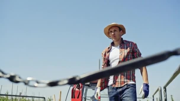 From below view of farmer loading lumber in truck on rural land with field on background. — Stock Video