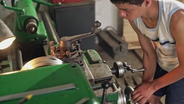 Adolescente examinando torno en taller — Vídeo de stock