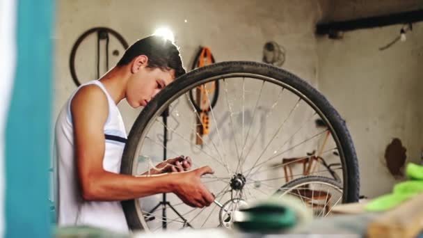 Adolescente trabajando en la rueda de su bicicleta — Vídeos de Stock