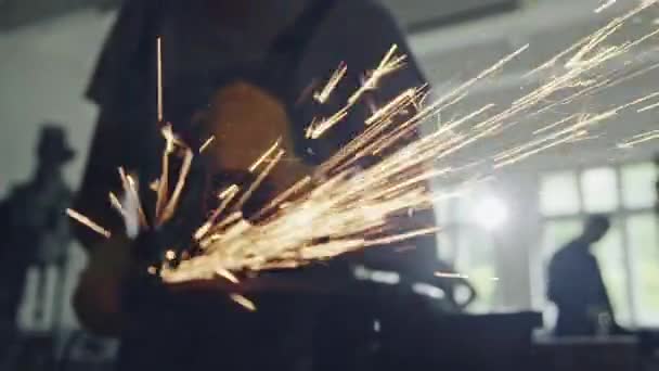 Closeup view of flying sparks from angle grinder in use by anonymous worker — Stock Video