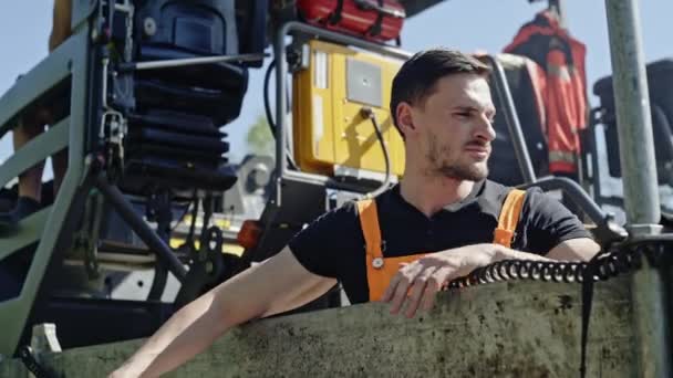 Arbeiter steuern eine Maschine, die Asphalt gleichmäßig auf die Fahrbahn bringt. — Stockvideo