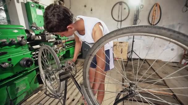 Jeune adolescent garçon réparer son vélo — Video