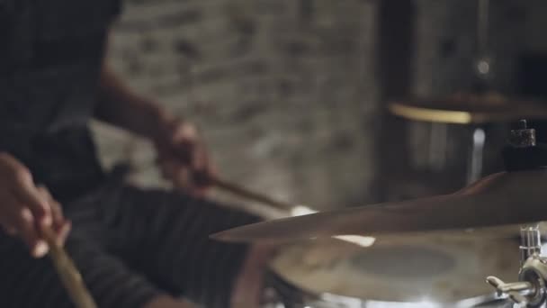 Барабанщик в рок-группе, играющей на барабанах и тарелках с барабанными палочками в крупном плане обрезанный вид инструментов во время живого выступления на сцене ночью . — стоковое видео