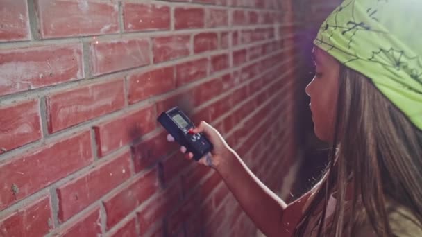 Menina com ferramenta eletrônica na casa de construção — Vídeo de Stock