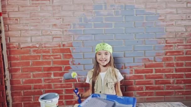 Una giovane ragazza felice e sorridente in un tema di pittura murale e ristrutturazione — Video Stock