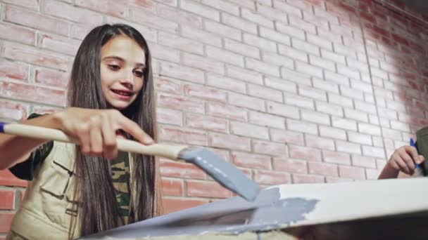Teenager benutzt blaue Farbe, um weiße Fliesen zu dekorieren — Stockvideo