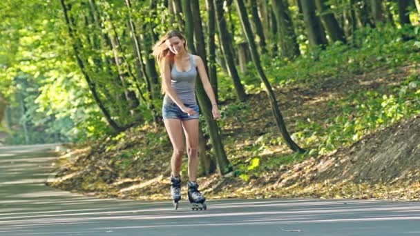 Jeune adolescente patin à roulettes à travers les bois — Video