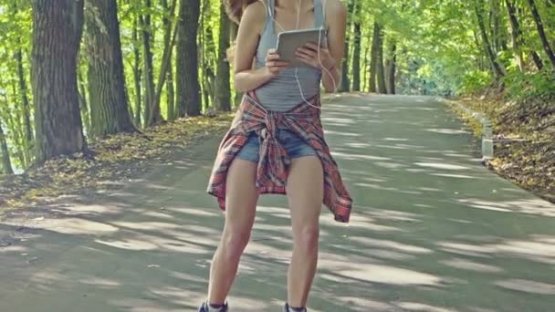 A bela jovem patinadora no parque . — Vídeo de Stock