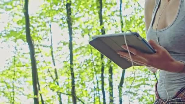 Mujer joven escuchando música en una tableta — Vídeos de Stock