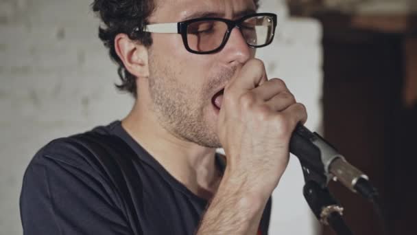 Solista de la banda de rock canta en el micrófono en el ensayo del grupo - cámara lenta — Vídeo de stock