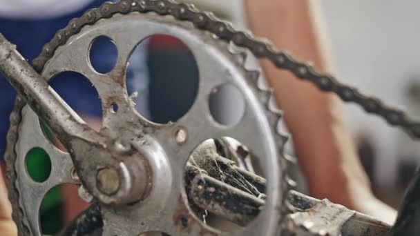 De arme rurale tiener zijn oude fiets reparaties en controleert het pedaal mechanisme - close-up. — Stockvideo