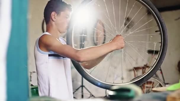 Tonårspojke reparera och balansera cykelhjul — Stockvideo