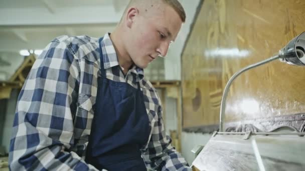 En ung man som manuellt Takås en bit av timmer — Stockvideo