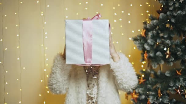 Happy νεαρό κορίτσι προσφέροντας δώρο Χριστουγέννων στην κάμερα — Αρχείο Βίντεο